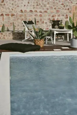 a swimming pool in front of a brick wall at LA Casa Di Lusso N4 - Adults Only in Kolimbia