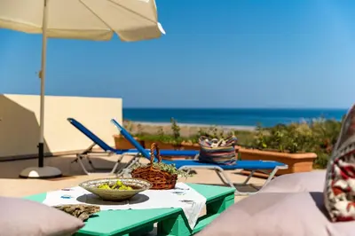 a table with a bowl of food on it with the beach at House Almyra in Lachania