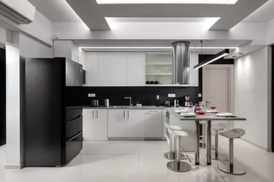 a kitchen with white cabinets and a table with stools at Rhodes SkyLine Suites in Ixia