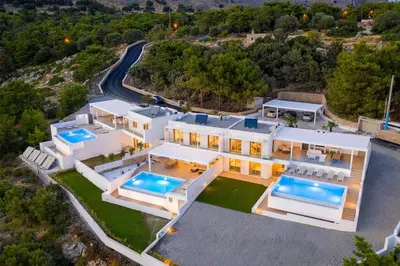 an aerial view of a house with two swimming pools at Villa Mimosa in Pefkos (Lindos area) in Líndos