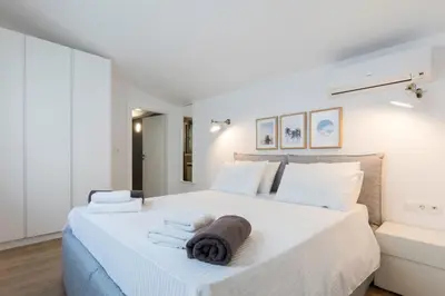 a white bedroom with a large bed with towels on it at Villa Crystal with swimming pool in Lindos in Líndos