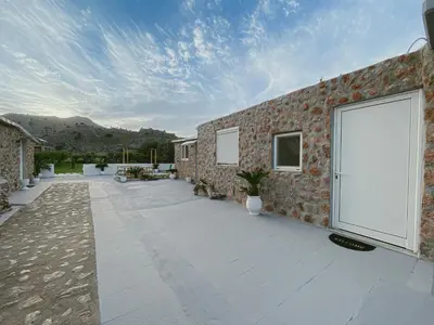 a stone house with a large white door on a patio at LA Casa Di Lusso N5 - Adults Only in Kolimbia