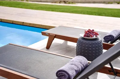 a table and chairs next to a pool with a bowl of fruit at Luxury Rhodes Villa Amina Villa Sea View Private Swimming Pool in Rhodes Town