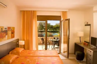 a bedroom with a bed and a desk and a balcony at Executive Rhodes Villa 4 Bedroom 4 Bathroom Bd Villa Pefkos in Pefki Rhodes