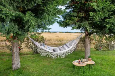 a hammock hanging between two trees in a field at Ilaira Sea View Bungalow in Gennadi