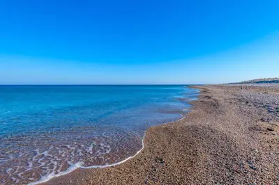 a beach with blue water and a rocky shore at Seashore Villa - Luxury Beachfront - Pool & Sea View in Lachania
