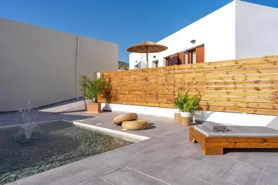 a backyard with a wooden fence and a bench at Giorgio Deluxe Studio in Kattavía