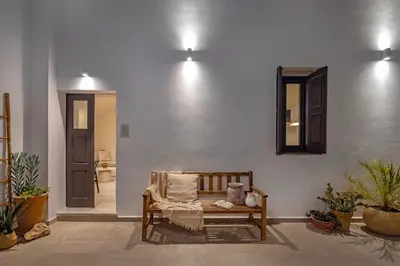 a room with a bench and a mirror on a wall at Noema Lindos - Agapitos Apartment in Líndos