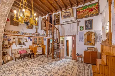 a living room with a chandelier and a staircase in a house at Beautiful historic house in Koskinou