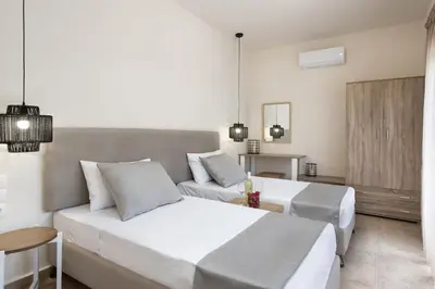 a bedroom with a large white bed and a couch at ANASTASIOS HOUSE STEGNA - UP FLOOR in Archangelos