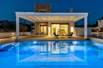 a villa with a swimming pool at night at Villa Lara AmberBlue Pefkos in Pefki Rhodes