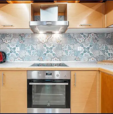 a kitchen with a stainless steel oven and wooden cabinets at Amaryllis front beach hotel in Lardos