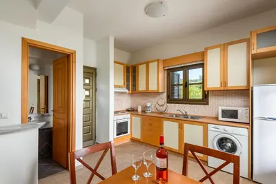 a kitchen with a table with wine glasses on it at Aegean Blue Villa's - All Inclusive & Water park in Kalathos
