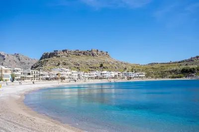 a view of a beach with a mountain in the background at New Loft by Ossiano Pool Villas, Heating Pool,2 min drive to Haraki Beach & 10 to Lindos in Haraki
