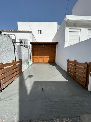 a garage with a wooden door on the side of a building at Maroulitsas Sea Esta 1 in Haraki