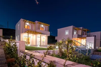 a large white house at night with lights at Villa Regina - Double Pool Paradise in Lachania