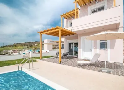 a house with a swimming pool and an umbrella at Regina Villa - Family Dream with double pool in Lachania