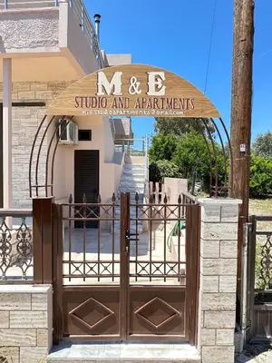 an entrance to a building with a wooden gate at M&E APARTMENTS in Haraki
