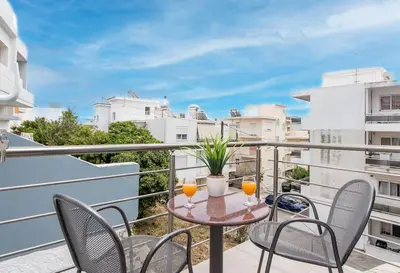 a balcony with chairs and a table with two glasses at Modern Colorful House 2 rhodos in Rhodes Town